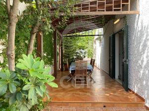 a patio of a house with a table and chairs at Villa Stella La tina - Spiaggia a 300m By Cala Salento in Torre Lapillo