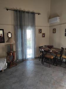 ein Esszimmer mit einem Tisch und Stühlen sowie ein Zimmer mit einem Fenster in der Unterkunft Near AirportAnd metropolitan Penelopi Cozy Home in Artemida