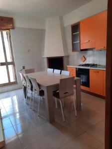cocina con mesa de madera y sillas en Casa Ercole, en Torre dell'Orso