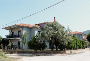a white house with trees in front of it at Aliston Hotel Thassos in Skala Potamias