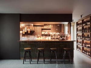 a bar with three stools in a room at Locanda Via Priula in Morbegno