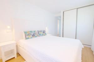 Un dormitorio blanco con una cama blanca y una ventana en Penthouse with rooftop pool - Duna Parque Group en Vila Nova de Milfontes
