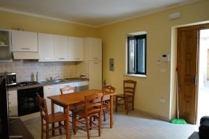 cocina con mesa de madera y sillas en una habitación en Casa con 3 camere da letto LOMBARDA ALTA en Falerna