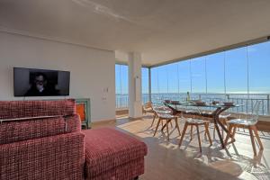 salon ze stołem, krzesłami i telewizorem w obiekcie 055 - Gran Playa Views - comfortHOLIDAYS w mieście Santa Pola