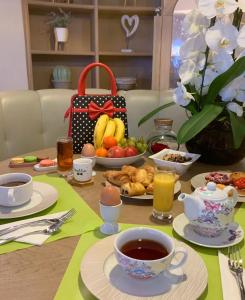 - une table avec petit-déjeuner composé d'œufs, de fruits et de jus dans l'établissement Hotel Le Revest, à Sainte-Maxime