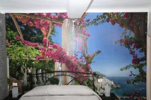 a bedroom with a view of the ocean and flowers at Le case di Elisa 4 in Genoa