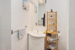 W białej łazience znajduje się umywalka i lustro. w obiekcie nid2nuit Nuance d'Ocres w Apt