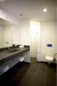 uma casa de banho com um lavatório, um WC e um espelho. em Hotel Strandtangen em Skive
