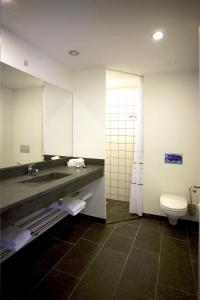 a bathroom with a sink and a toilet and a mirror at Hotel Strandtangen in Skive