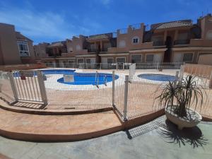 a fence in front of two swimming pools at La Union in Cuevas del Almanzora