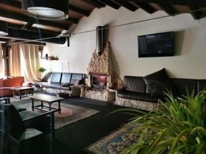 a living room with leather furniture and a fireplace at Hotel Las Truchas in Nuévalos