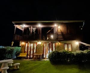 a house with a porch at night with lights at เฮือนฮอมคำโฮมสเตย์(Huanhomkham homestay) in Chiang Mai