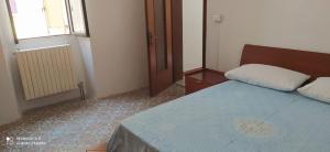 Appartamento Olimpo: Biella في بييلا: غرفة نوم صغيرة مع سرير ومرآة
