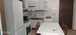 Appartamento Olimpo: Biella في بييلا: مطبخ مع طاولة وثلاجة بيضاء