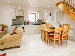 a kitchen and dining room with a table and chairs at May's Cottage in Bushmills