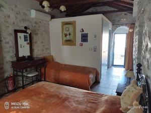 1 dormitorio con cama, escritorio y espejo en Petrounis Hotel, en Areopoli