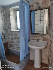 a bathroom with a sink and a mirror at Petrounis Hotel in Areopoli