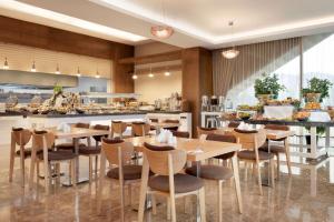 a restaurant with tables and chairs and a kitchen at Ramada Iskenderun in İskenderun