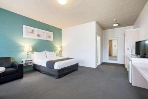 a bedroom with a bed and a couch and a television at Comfort Inn & Suites King Avenue in Sale