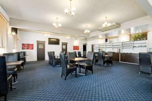 a dining room with tables and chairs at Comfort Inn & Suites King Avenue in Sale