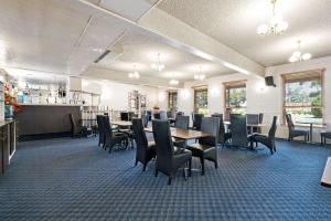 een eetkamer met tafels en stoelen in een restaurant bij Comfort Inn & Suites King Avenue in Sale