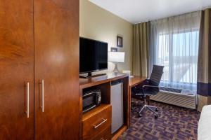 Habitación de hotel con TV y escritorio con ordenador. en Comfort Inn & Suites North Aurora - Naperville en Aurora