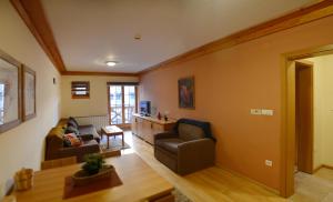 Una sala de estar con dos sillas y un sofá. en Jahorina Apartmani Vučko F&F, en Jahorina