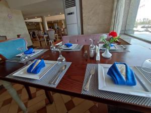 a wooden table with two white plates and blue napkins at 26th of July Apartments in Alexandria