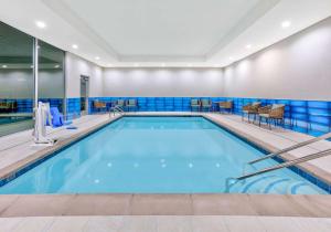 La Quinta Inn & Suites by Wyndham Terrell في تيريل: حمام سباحة في غرفة الفندق مع بلاط أزرق