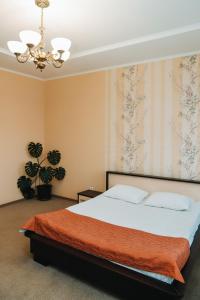 a bedroom with a bed and a chandelier at Готель Релакс in Korostyshiv