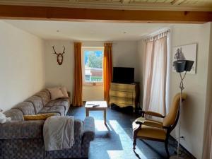 a living room with a couch and a chair at on a quiet location, beautiful, spacious holidayhouse, only for holidays, with a fantastic view, perfect for skiing, walking and hiking in Scheid