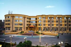 a large building with a parking lot in front of it at Jewel Glorious Hotel in Cairo