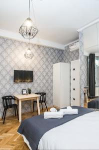 Schlafzimmer mit einem Bett und einem Tisch mit Stühlen in der Unterkunft Cracovia Wawel Apartments in Krakau