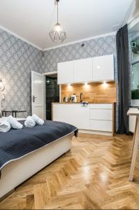a bedroom with a bed and a kitchen at Cracovia Wawel Apartments in Kraków