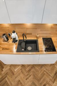 a kitchen with a sink and a wooden counter top at Cracovia Wawel Apartments in Kraków