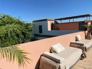 two chaise lounges and chairs on a balcony at Riad Magellan Yoga and Spa in Marrakesh