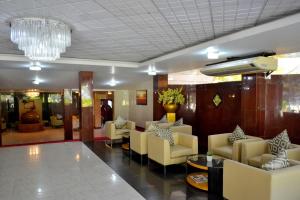 a lobby with couches and chairs and a chandelier at Good wood Airport Hotel in Katunayake