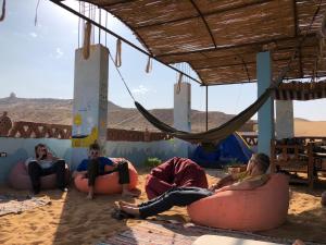 a group of people sitting on bean bags in the desert at Nubian Kingdom Aragheed House in Aswan
