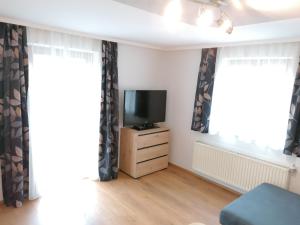 a living room with a tv and curtains at Ferienwohnung Holzer in Sankt Michael im Lungau