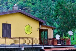ein gelbes Gebäude mit einem Balkon und einem Schild darauf in der Unterkunft Loggia Piani Nuovi in Carasco