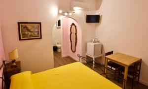 Zimmer mit einem Bett, einem Tisch und einem Spiegel in der Unterkunft Loggia Piani Nuovi in Carasco