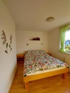 摩拉瓦托普利采的住宿－Apartma TiJa，一间卧室配有一张带花卉床罩的床