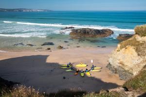 a group of people with surfboards on a beach at Three Mile Beach in Hayle