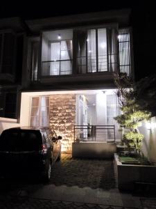 une voiture garée devant une maison la nuit dans l'établissement Villa Keluarga Batu, à Batu