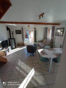 a living room with a table and a couch at Gite La Hulotte in Saint-Laurent-sur-Mer