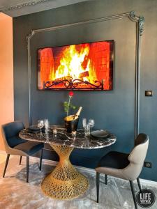 a dining room with a table and a fireplace at LIFE VOYAGE & SPA by Life Renaissance in Strasbourg