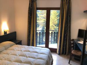 1 dormitorio con 1 cama y ventana con balcón en petit paradis en Champorcher