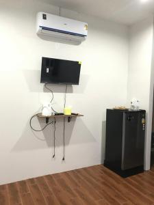 ein Zimmer mit Schreibtisch, Fernseher und Heizung in der Unterkunft บ้านพักดีมีทรัพย์ Baan PakDee Meesub in Uthai Thani