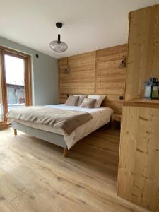 1 dormitorio con 1 cama grande y paredes de madera en Le terrier, en Vaujany