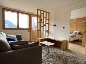 a living room with a couch and a bed at Le terrier in Vaujany
